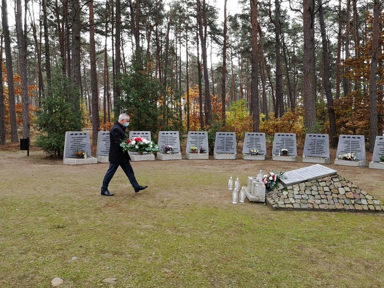 Burmistrz Tucholi Tadeusz Kowalski składa wiązankę kwiatów przy Pomniku Pomordowanych w lesie w Rudzkim Moście